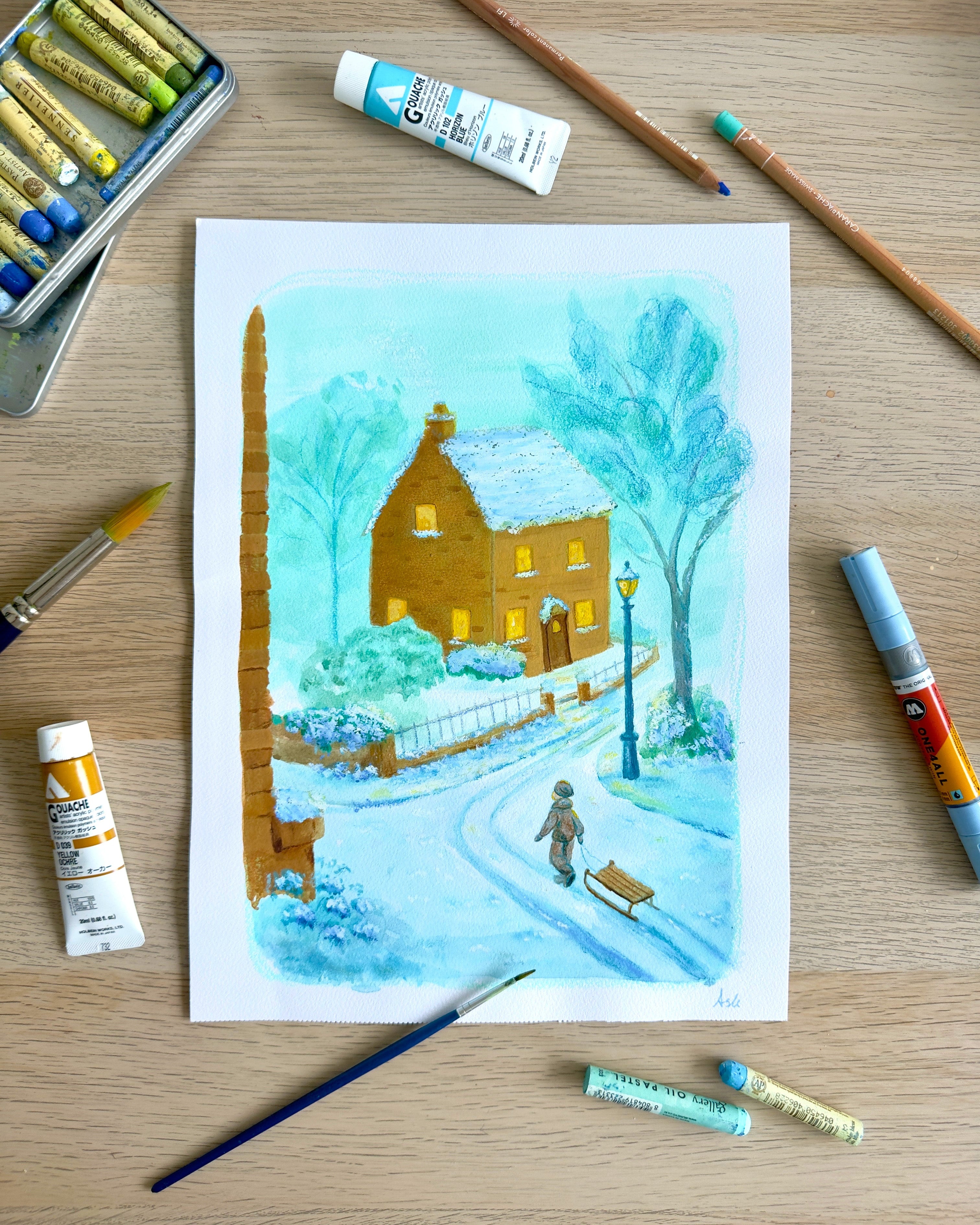 Winter scene painting on a wooden surface with art supplies